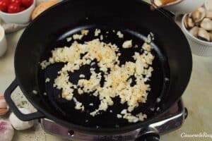onions and garlic being sauteed to make italian baked rice and clams
