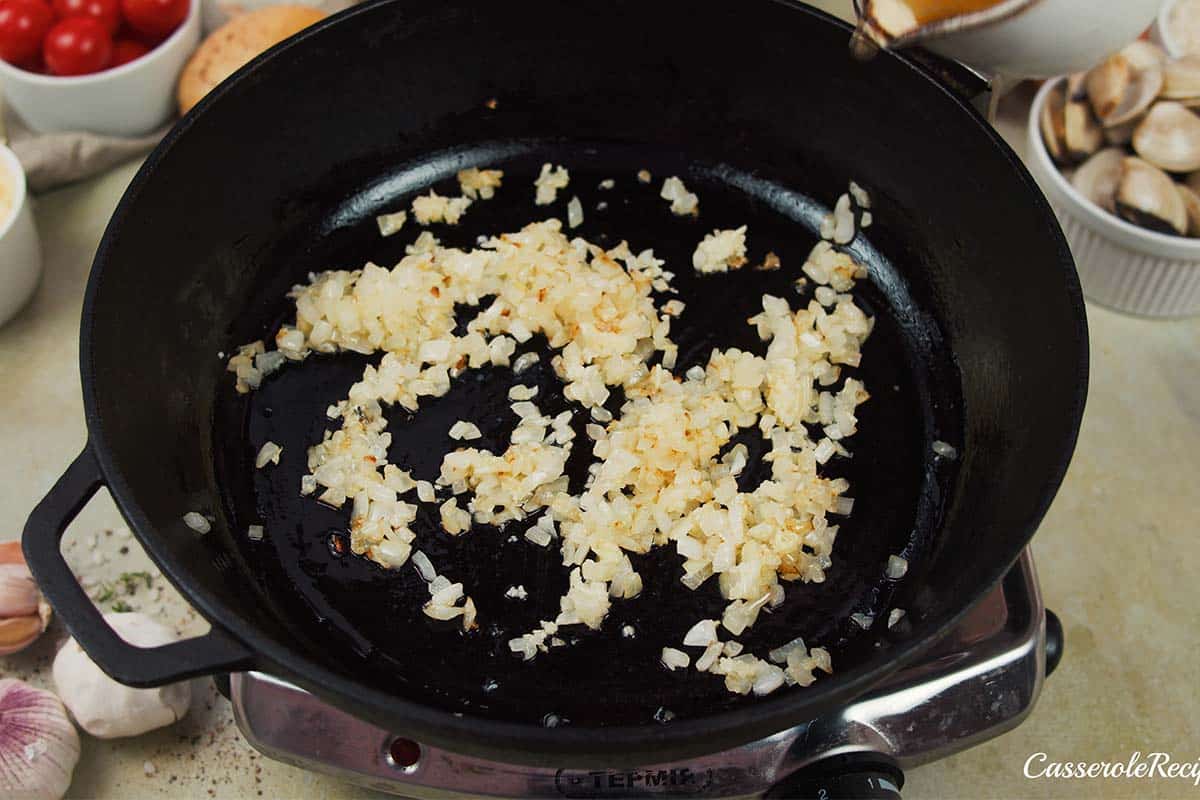 onions and garlic being sauteed to make italian baked rice and clams