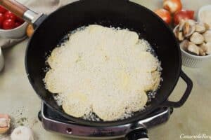 layering ingredients in a cast iron skillet to make italian baked rice and clams
