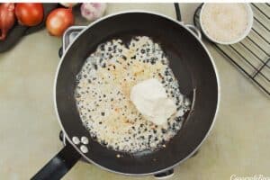 onion and garlic being sauteed with butter and other ingredients to make no-peek chicken casserole