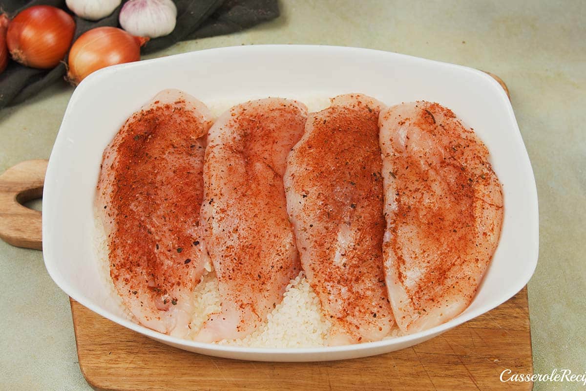 layering chicken in a baking dish to make no-peek chicken casserole