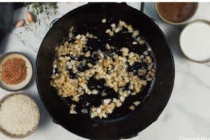 onions being sauteed to make One Pot Caribbean Jerk Chicken & Rice